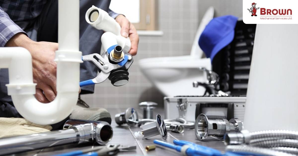 Commercial plumbing repair technician fixing pipes at a business location